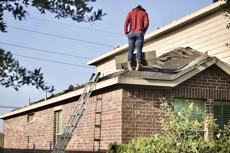 Professional roofer working on a residential roof in Twelve Oaks